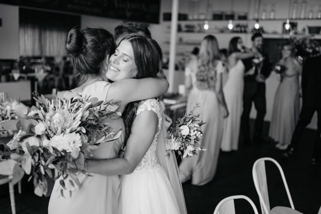 Joyful wedding embrace between brides at a celebration, capturing love and happiness.