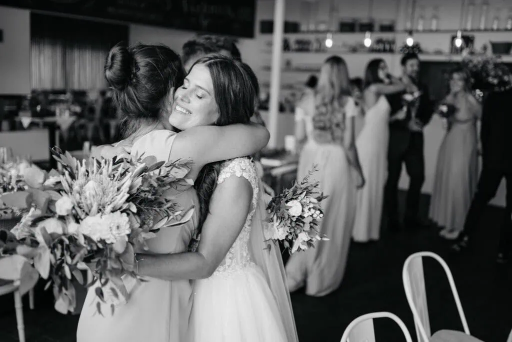 Joyful wedding embrace between brides at a celebration, capturing love and happiness.