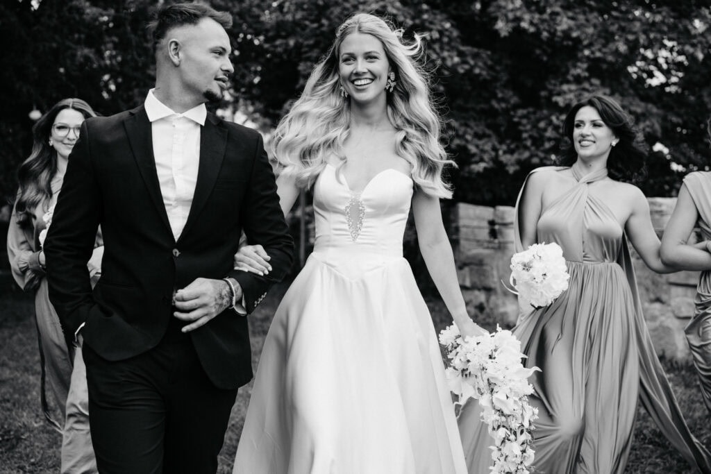 Elegant wedding celebration with bridesmaids and groom at outdoors venue.