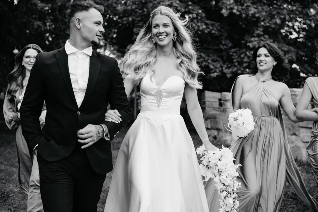 Elegant wedding celebration with bridesmaids and groom at outdoors venue.