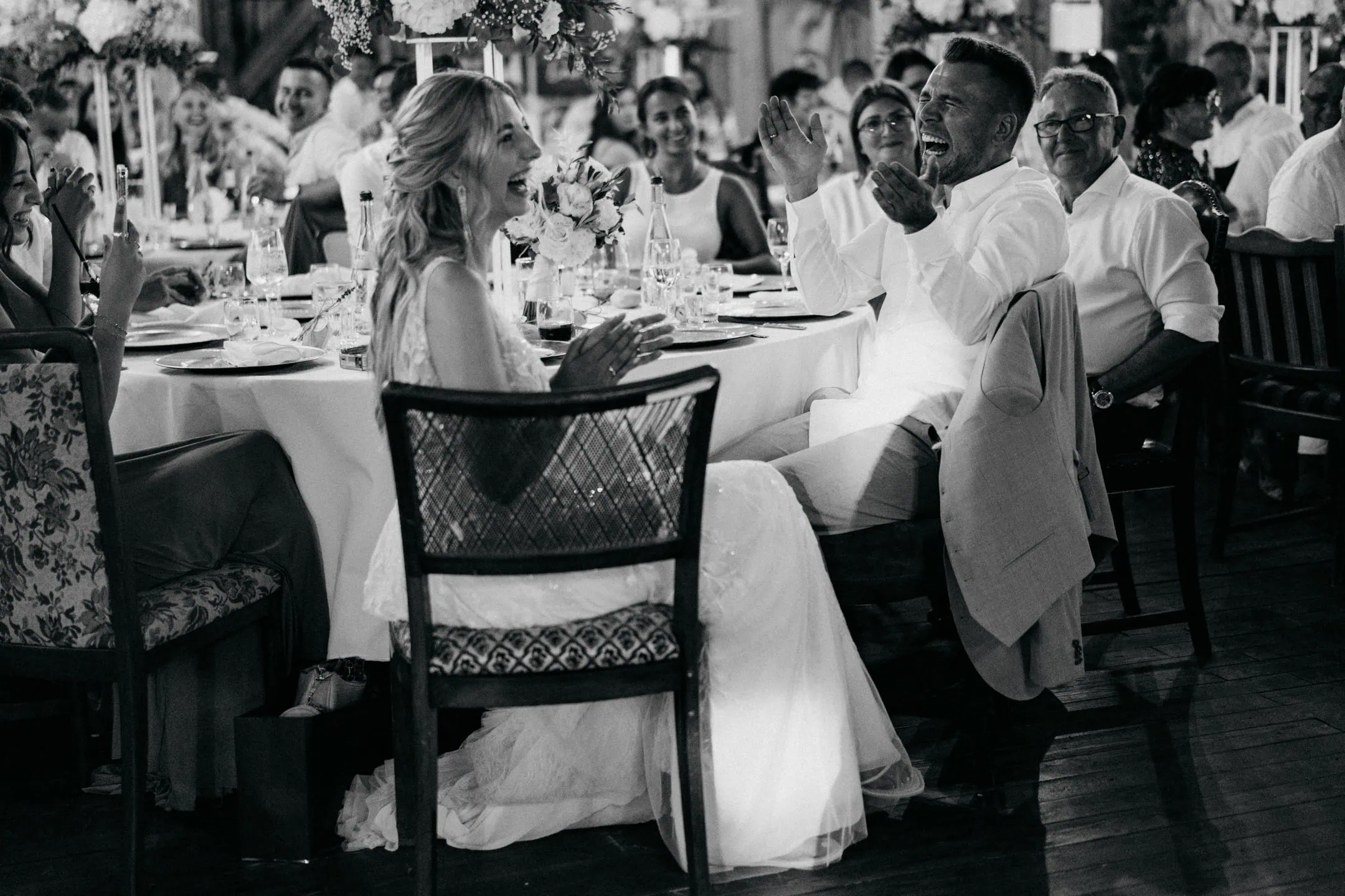 Joyful wedding reception featuring laughter and celebration at a formal event.