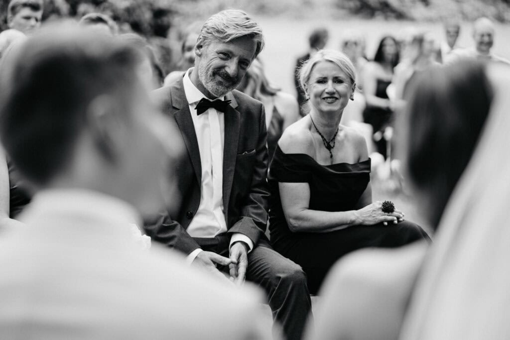 Elegant wedding ceremony with joyful guests and heartfelt moments captured in black and white.