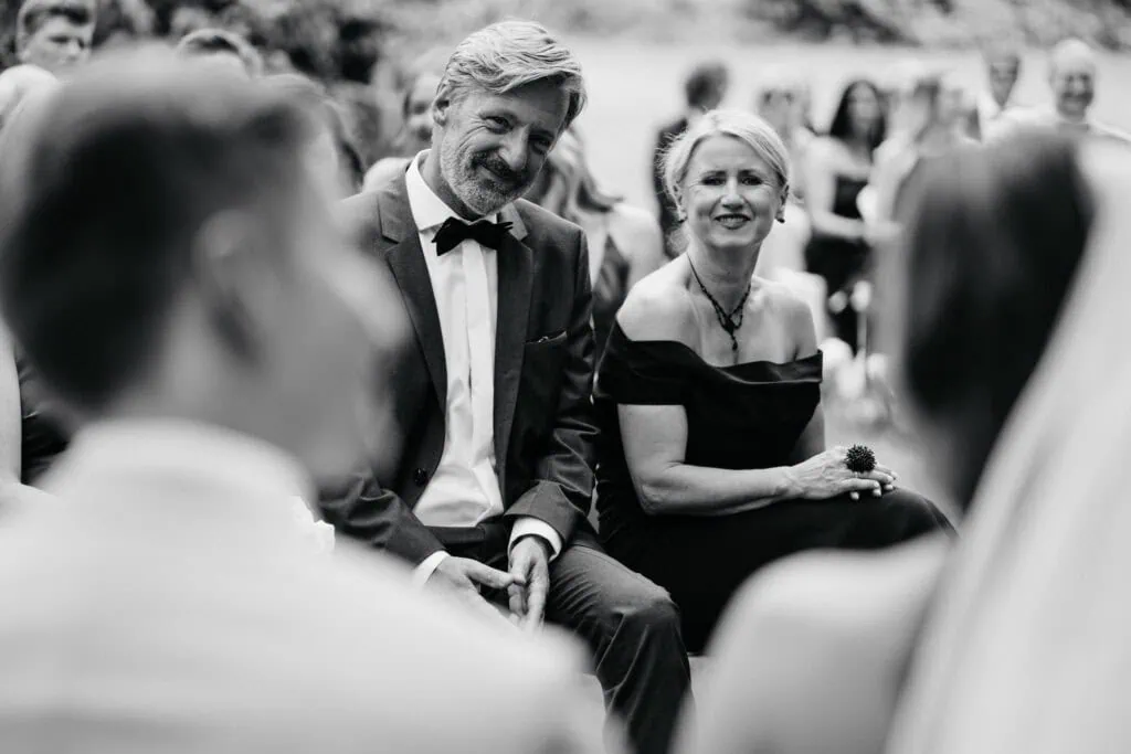 Elegant wedding ceremony with joyful guests and heartfelt moments captured in black and white.