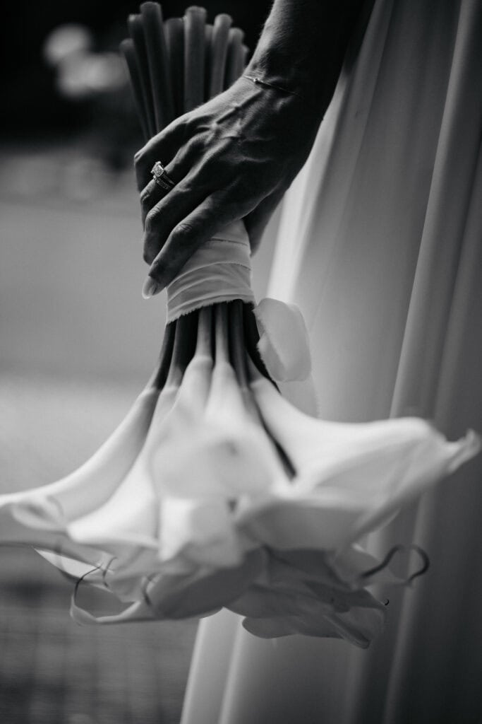 Gentleman holding calla lilies at wedding, black and white, elegant floral arrangement, event, romance, celebration, theatre of real life.