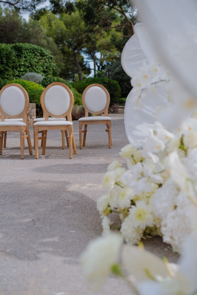 Elegante Hochzeitsstühle im Freien mit Blick auf üppiges Grün