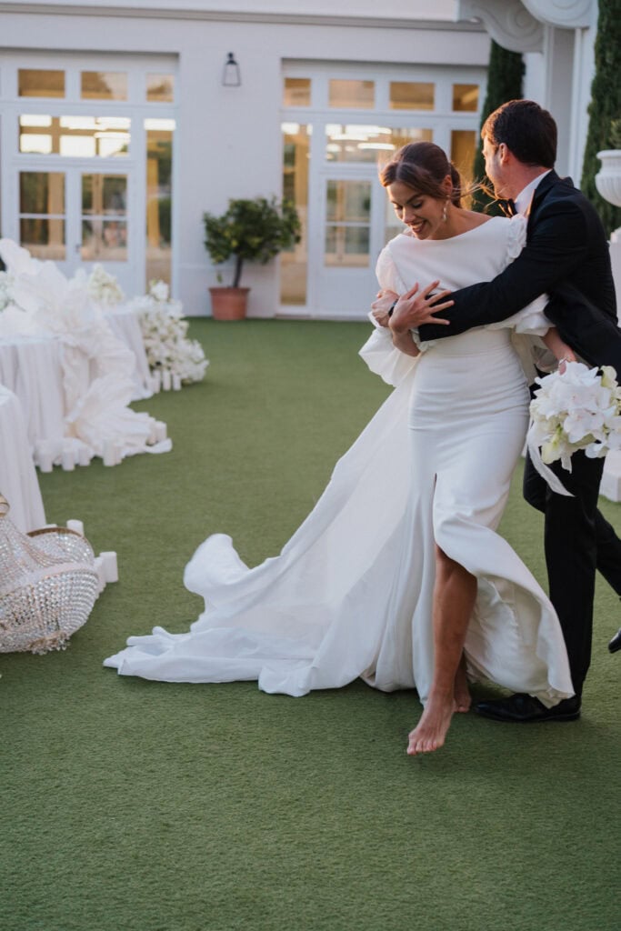 Eleganter Hochzeitstanz mit einer Braut in einem weißen Kleid und einem Bräutigam in einem schwarzen Smoking an einem wunderschönen Ort im Freien.